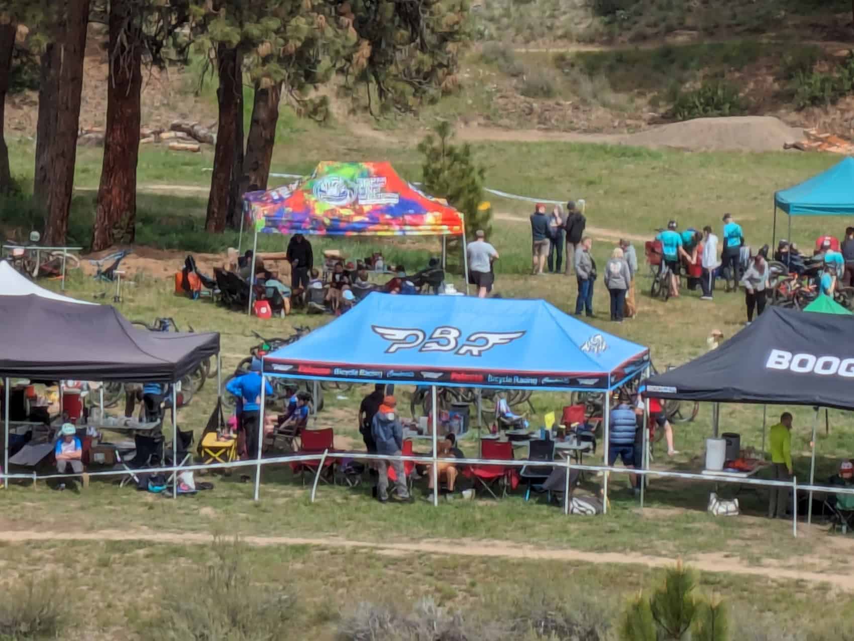 A view of the bike village with multiple team tents and people.